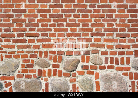 Closeup view of old wall of medieval castle made of red bricks and stone Stock Photo