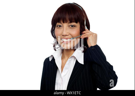 Cheerful asian customer support operator wearing headsets isolated over white background Stock Photo