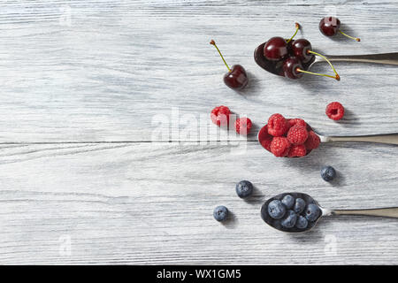 Fruits pattern of fresh blueberries, cherries, raspberries on wooden table. Stock Photo