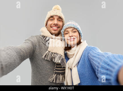 happy couple in winter clothes taking selfie Stock Photo
