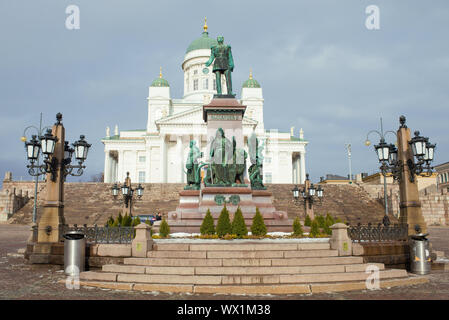HELSINKI, FINLAND - MARCH 08, 2019: Monument to Russian Emperor Alexander II against the background of St. Nicholas Cathedral on a cloudy March day. Stock Photo