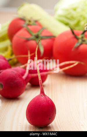 fresh   raddish and vegetables over pine wood table closeup Stock Photo