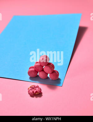 Original composition of colorful macaroons on a blue pink paper background Stock Photo