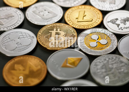 Set of different gold and silver coins of crypto-currencies on a dark background with bright light. Top view Stock Photo