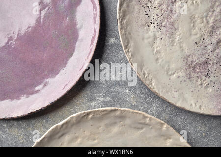 The porcelain vintage plates handmade on a gray marble table. Stock Photo
