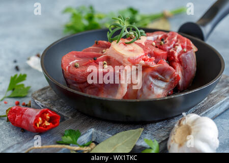 Piece of raw beef shank for Osso Buco and a sprig of rosemary. Stock Photo