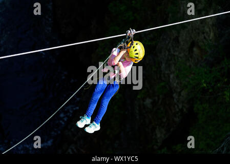 A young girl rides on a zipline at Canyon Sainte Anne in Quebec, Canada Stock Photo