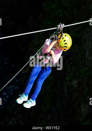 A young girl rides on a zipline at Canyon Sainte Anne in Quebec, Canada Stock Photo