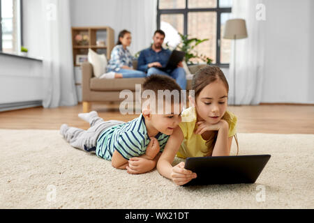 brother and sister with tablet computer at home Stock Photo