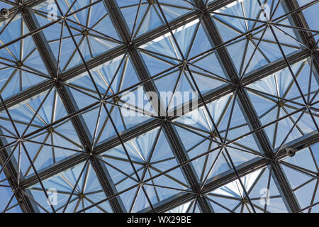 Transparent glass ceiling in modern office building against a blue sky Stock Photo