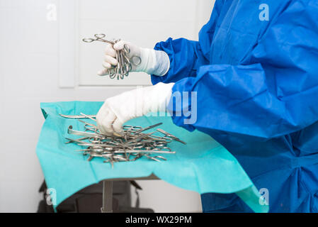 Scrub nurse preparing medical instruments for operation