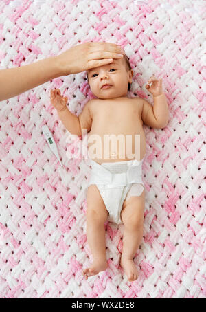 mother's hand measuring temperature of baby girl Stock Photo