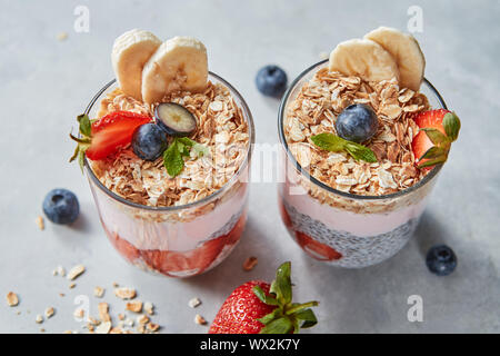 Dietary natural breakfast with natural organic ingredients - strawberries, granola, banana in a glass on a wooden table. Healthy Stock Photo