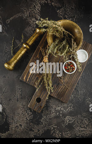 Thyme. Bunch of fresh herb thyme in bronxe mortar on rusty background Stock Photo