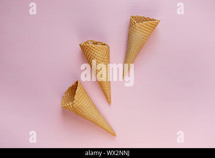 Three empty waffle cones on a pink background. Flat lay. Minimalism. Stock Photo