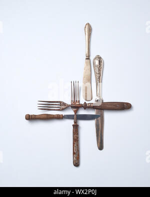 Pattern from metalic old knives and forks with wooden handles presented on a gray background with space for text. . Flat lay Stock Photo