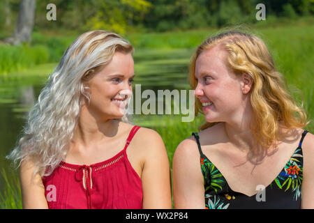 Two young women  smiling at each other Stock Photo