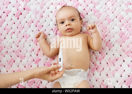 mother's hand measuring temperature of baby girl Stock Photo