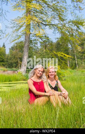 Two young dutch women sit together in nature Stock Photo