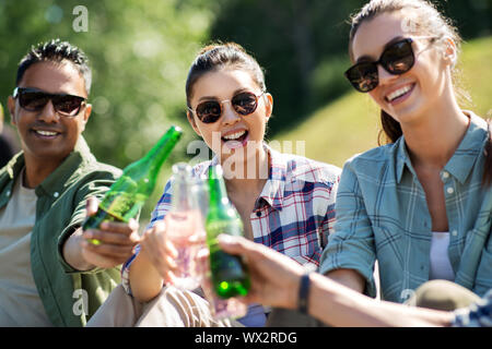 happy friends clinking drinks outdoors in summer Stock Photo