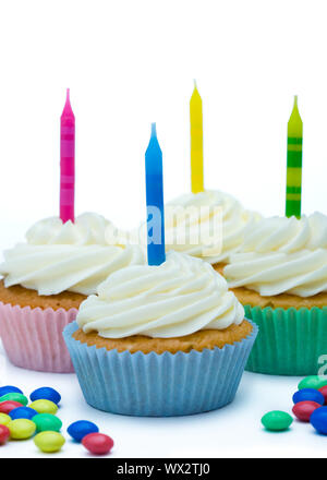 Cupcakes decorated with brightly colored candles Stock Photo