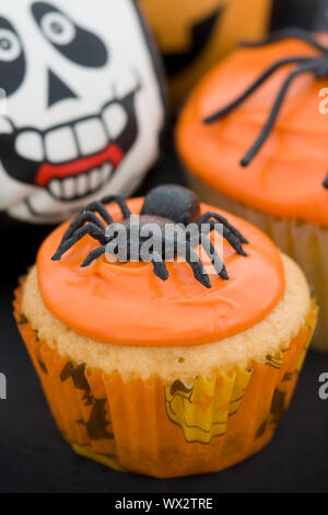 Cupcakes decorated with orange frosting and spiders Stock Photo
