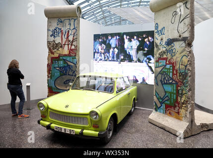 Original Berlin Wall with Trabi and film of the opening of the Berlin Wall in 1989, Bonn, Germany Stock Photo