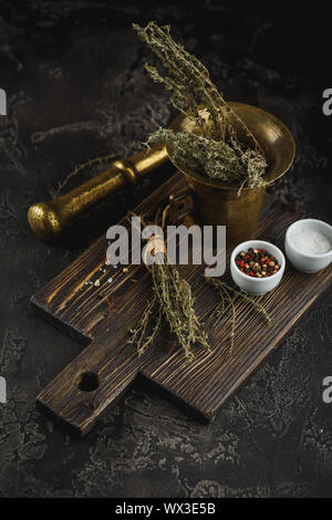 Thyme. Bunch of fresh herb thyme in bronxe mortar on rusty background Stock Photo