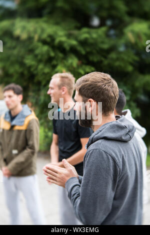 group of young people standing in a circle and praying together Stock Photo