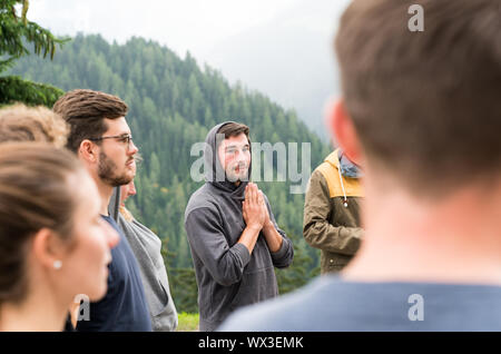 group of young people standing in a circle and praying together Stock Photo