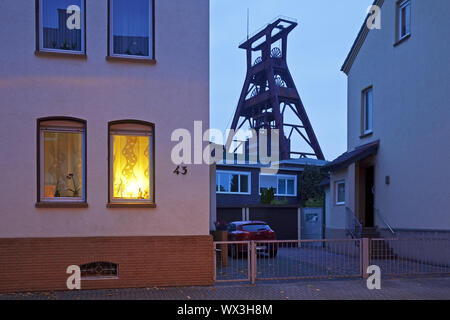 Residential buildings with the winding tower of Pluto colliery at dusk, Herne, Germany, Europe Stock Photo