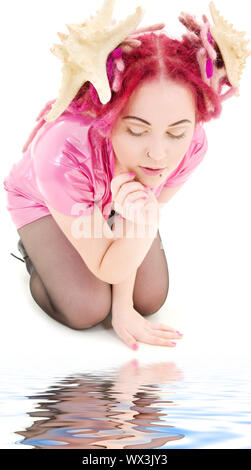 bizarre pink hair girl in latex dress looking into water Stock Photo