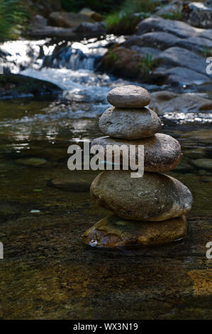 Zen rocks or pebble stack on river waters. Peaceful and spiritual theme Stock Photo