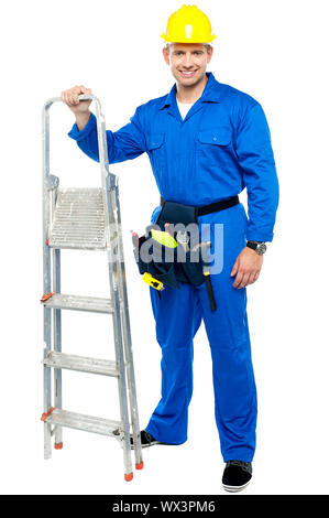 Young construction worker ready to get to work with stepladder isolated over white Stock Photo