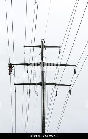 Man working on High Voltage Electric Power Lines at a distribution sub ...
