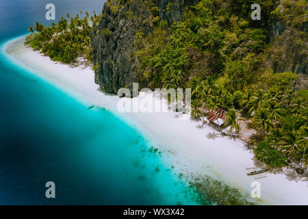 Pinagbuyutan Island, El Nido, Palawan, Philippines. Aerial drone photo of tropical hut surrounded by rocks, white sandy beach, coconut palms and Stock Photo