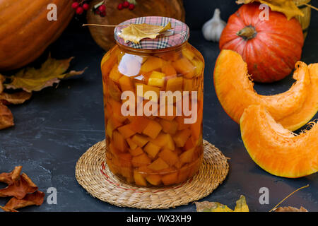 Pieces pumpkin in jar located on a dark background, harvesting vegetables for the winter, horizontal orientation Stock Photo
