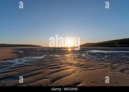 Landscape photo of the sun setting over Crantock beach in Cornwall Stock Photo