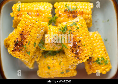British corn on the cob that has been bought from a UK supermarket and simmered in milk, butter and vegetable stock. It has been seasoned with black p Stock Photo