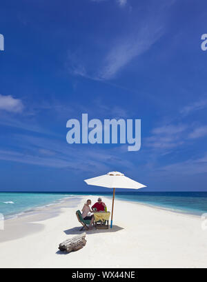 Lonely Maldives beach with tourists Stock Photo