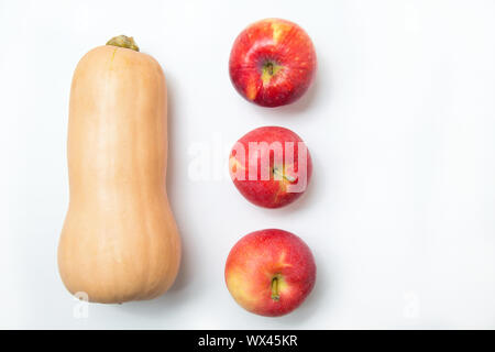Three red apples and yellow pumpkin on a white background. Copy space. Stock Photo