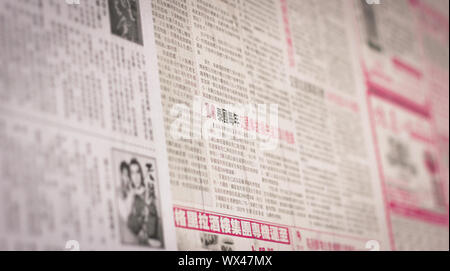 Bangkok, Thailand - October 09, 2016:  Sheet of Old Chinese Newspaper sticked on the billboard of old community center in Yaowarat Stock Photo