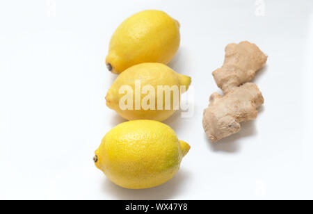 Three yellow lemons and ginger root on a light background. Stock Photo