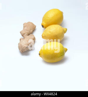 Three yellow lemons and ginger root on a light background. Stock Photo