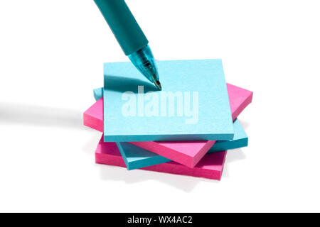 Image of blue and pink post it note paper with pen against the white background Stock Photo