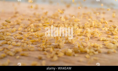 Bulgur raw grits in a pile with grains falling from above Stock Photo