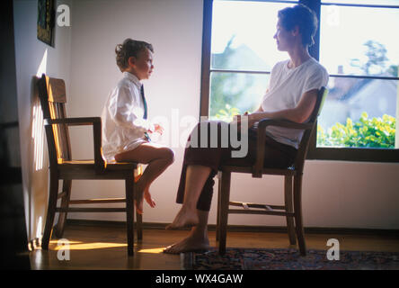 A half-dressed kid is talking to his mother. Stock Photo