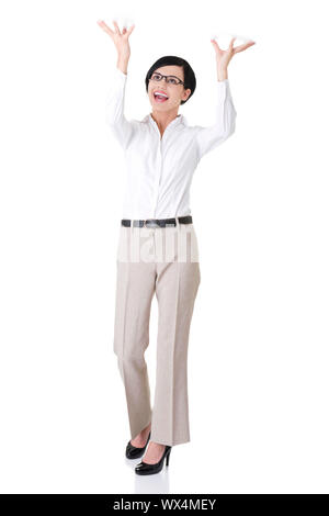 Smiling young woman  is holding something abstract above her head. Happy girl with raised hands. Isolated on white background. Stock Photo