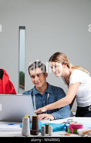 Young fashion designers working on laptop together Stock Photo