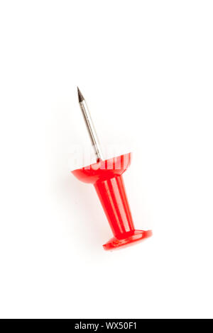 Close up of a red pushpin on the floor against a white background Stock Photo